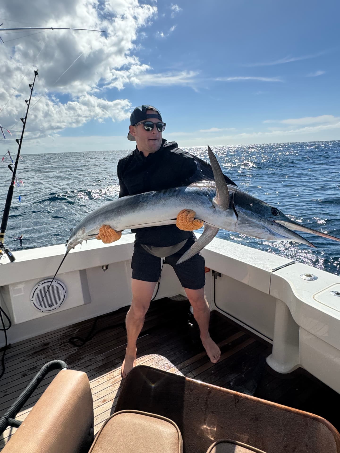 Angler holding a large marlin aboard a Cabo sportfishing boat