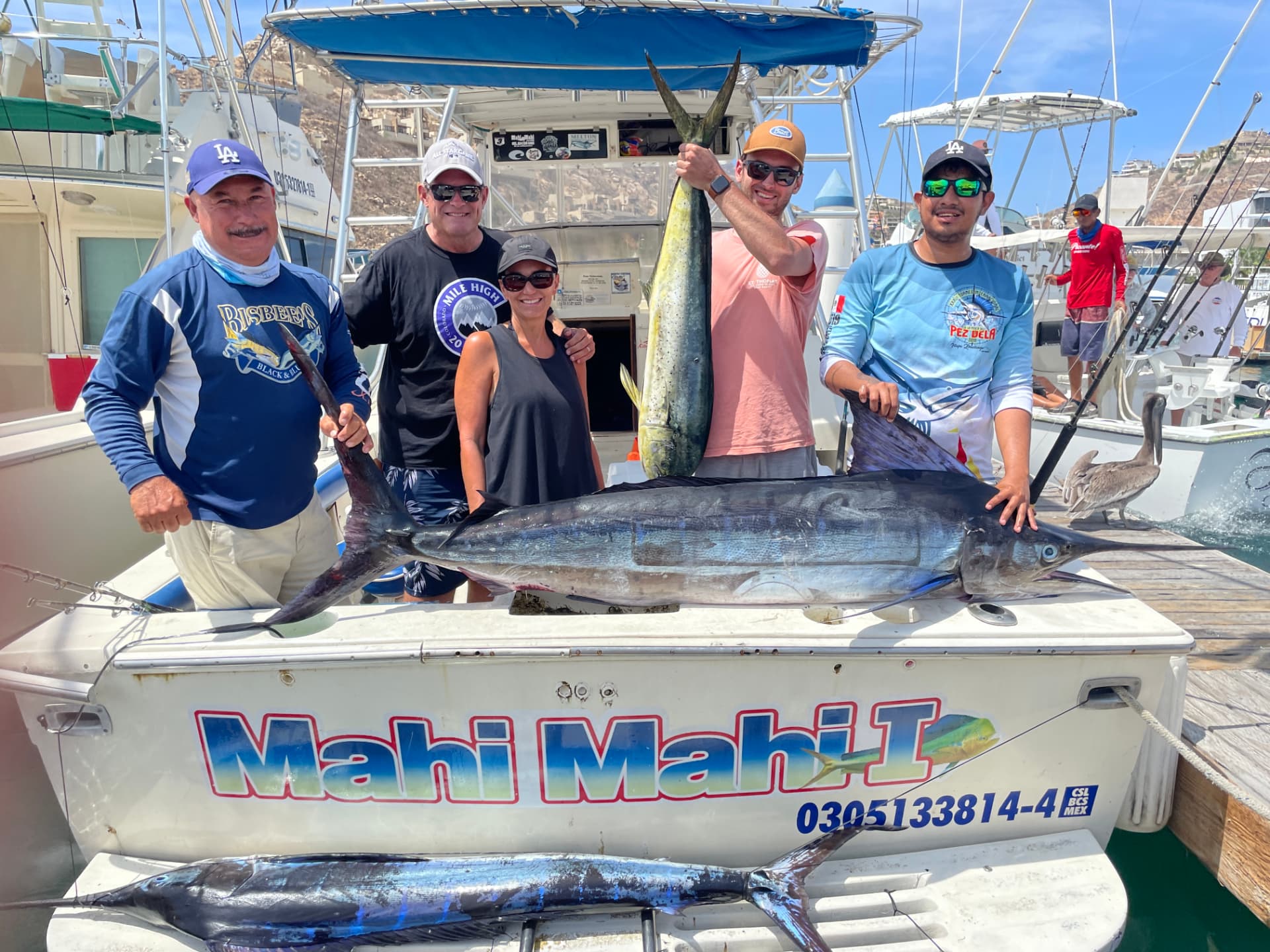 Cabo anglers and crew with a landed blue marlin and dorado at the marina